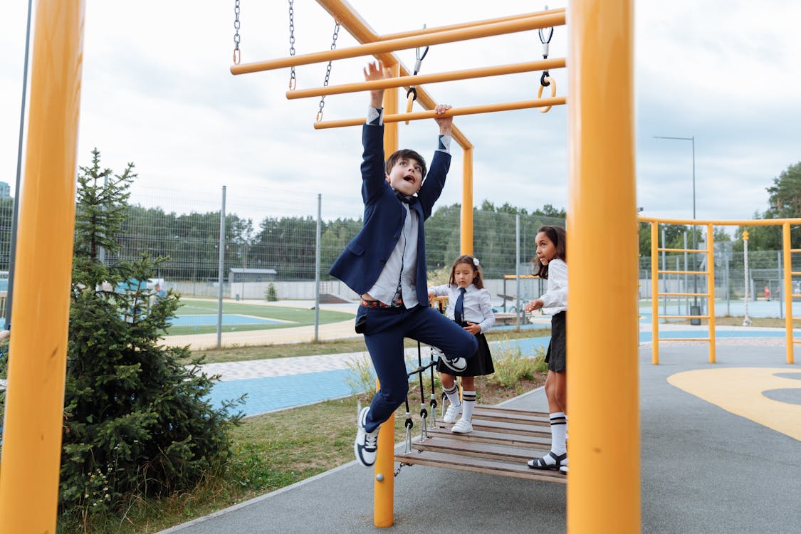 Free An Active Boy Hanging on Monkey Bars Stock Photo
