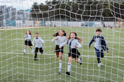 Children Running Towards the Soccer Net