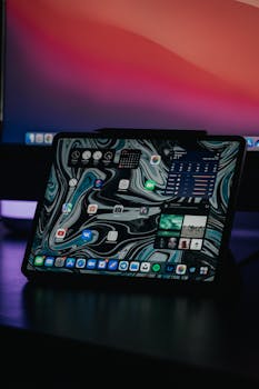 A modern tablet showcasing an abstract interface in a dimly lit environment, highlighting technology.