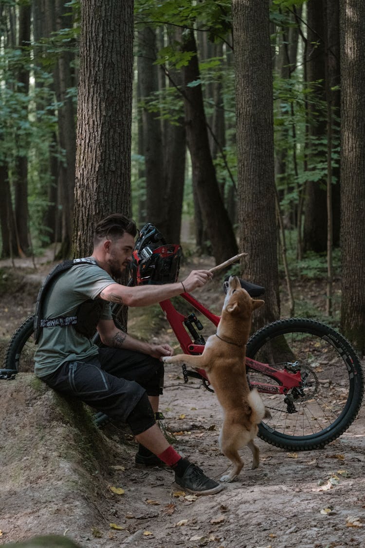 A Mountain Biker Paying With His Dog