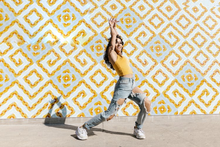 A Dancer In A Yellow Tank Top And Ripped Jeans