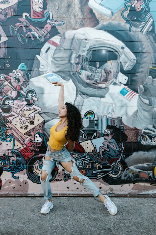 Free Woman Dancing with a Graffiti Wall Background Stock Photo