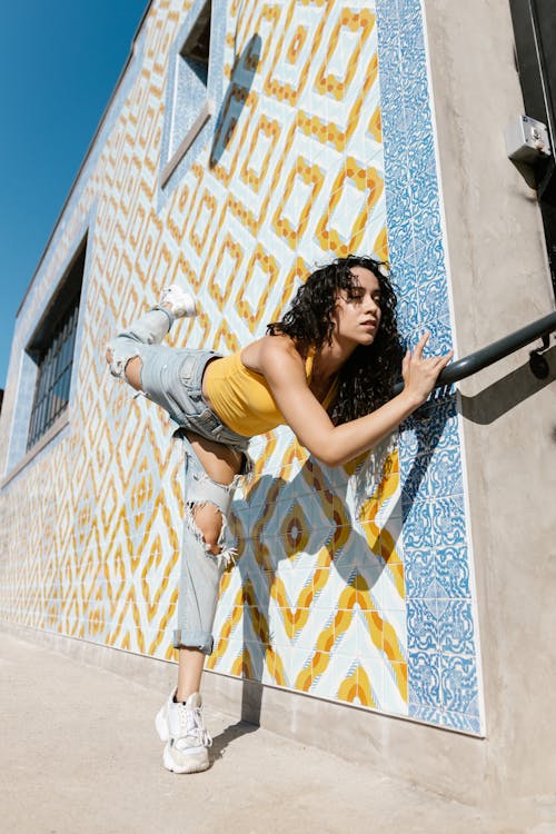 Woman Holding the Metal Railing with her Leg Raised