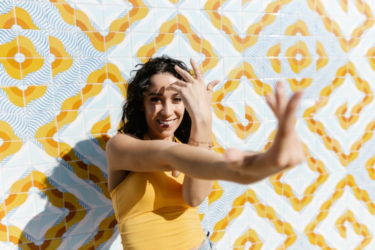 A Woman Posing By A Mosaic Wall