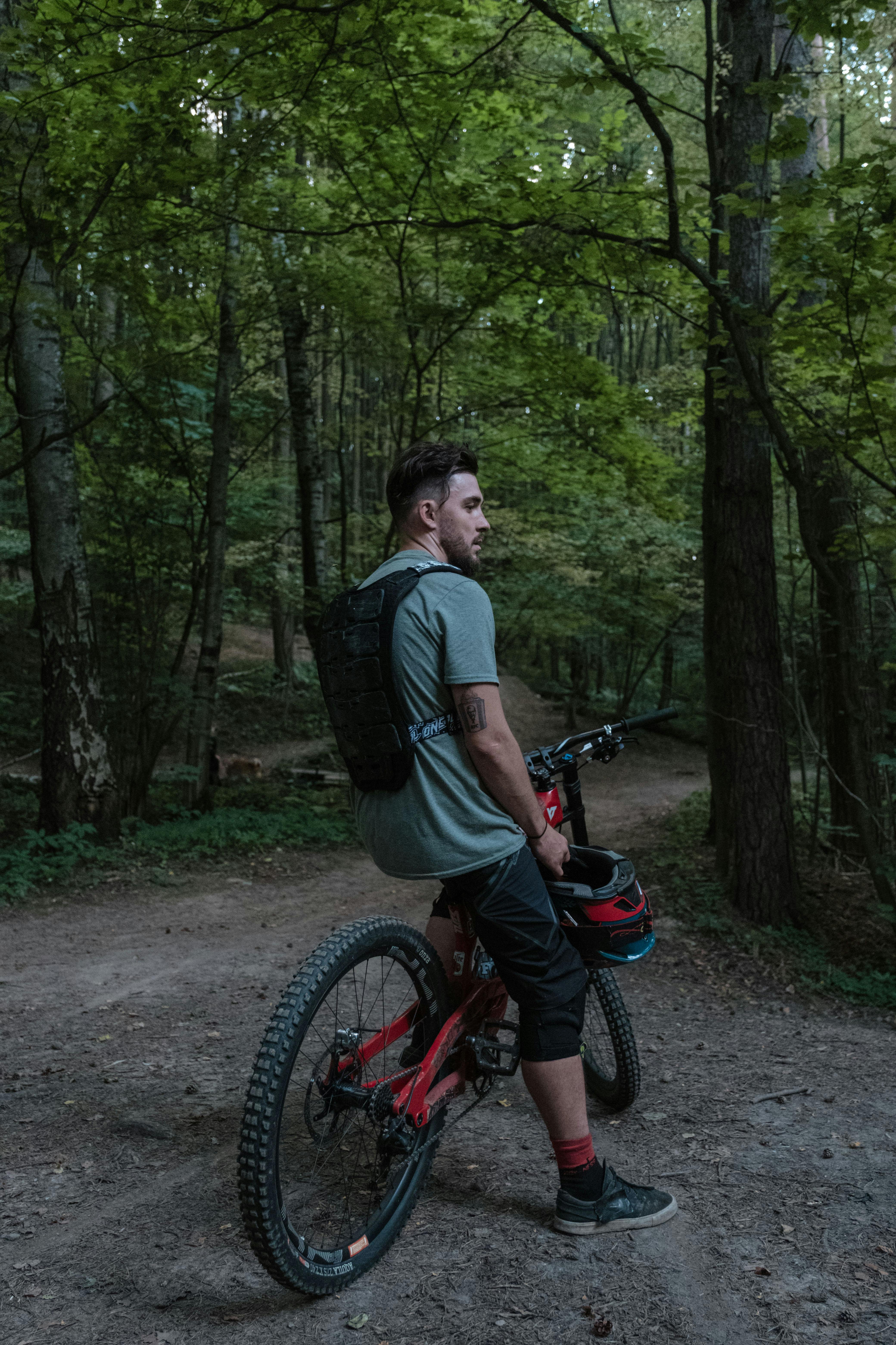 photo of a man in a green shirt riding a bicycle