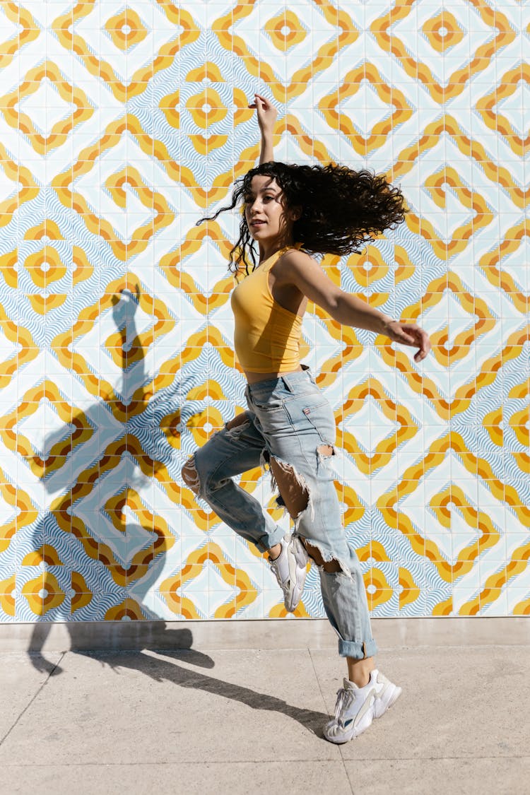 A Woman In Yellow Tank Top Dancing On The Street