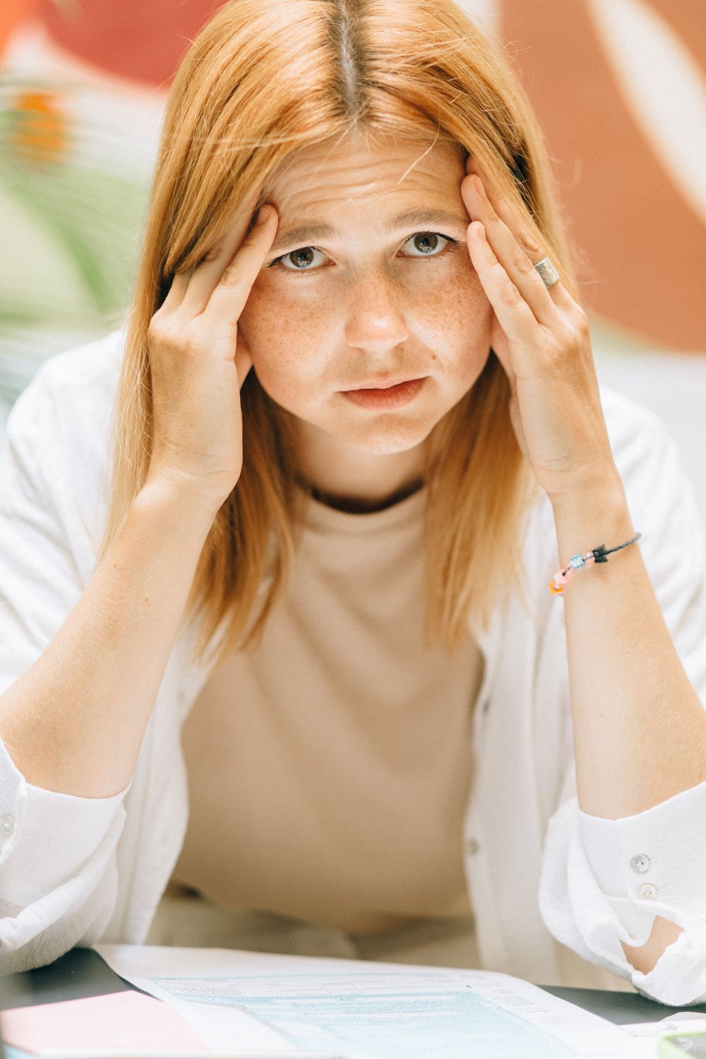 Can Stress Cause Bad Breath? The Anxiety Loop Nobody Warns You About 1 Young woman under stress at her desk, a common trigger for dry mouth and bad breath