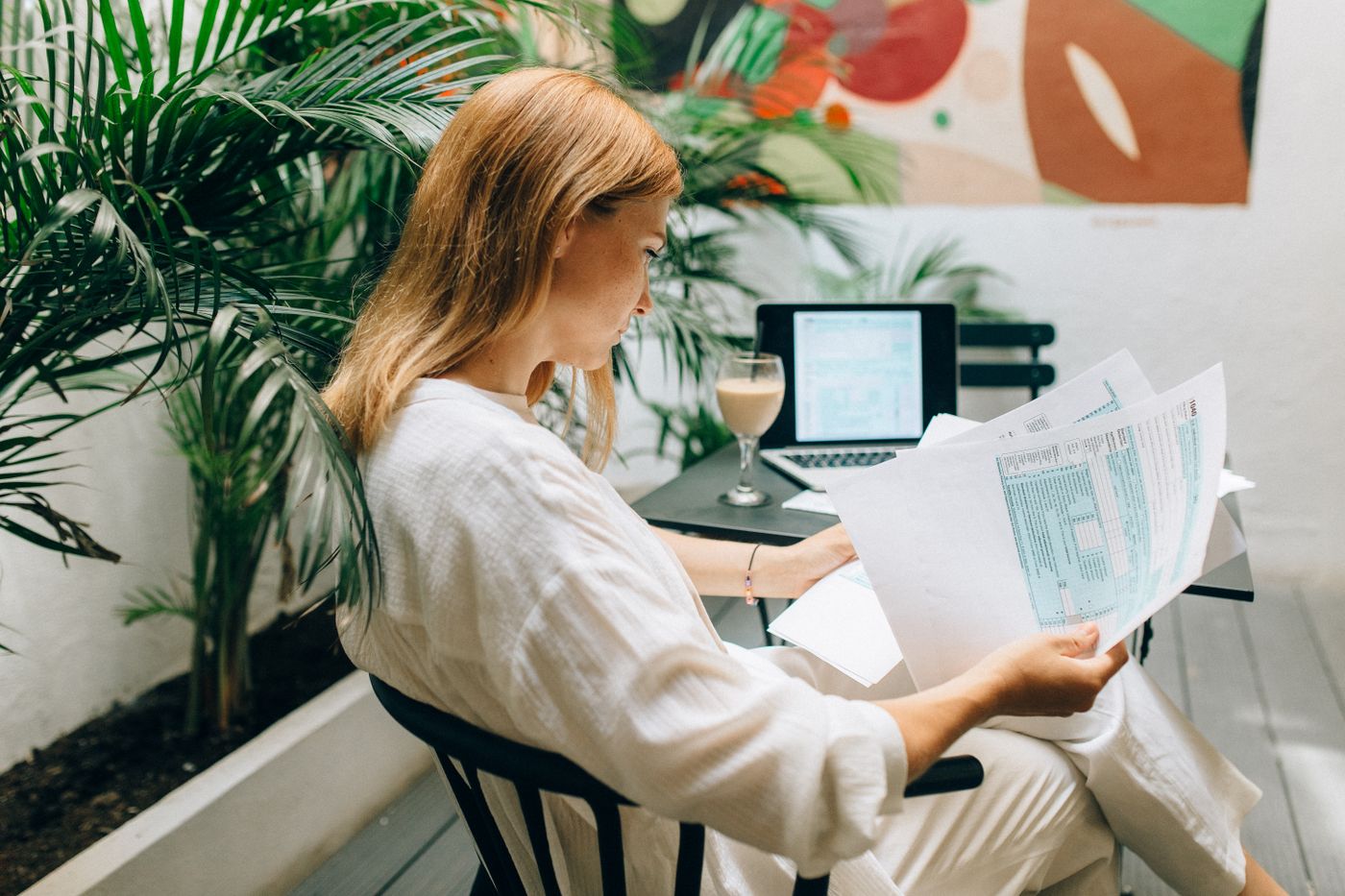 Woman reviewing business documents with a laptop