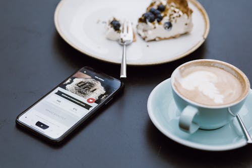 Free Black Smartphone Beside Coffee Mug in Shallow Focus Lens Stock Photo