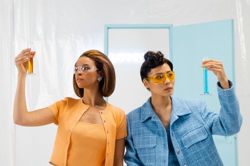 Free Two women scientists examining colored liquids in a modern laboratory setting. Stock Photo