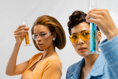 Women Holding Graduated Cylinders