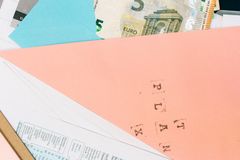 Close-up of colorful envelopes containing Euro notes and various papers, symbolizing financial planning.