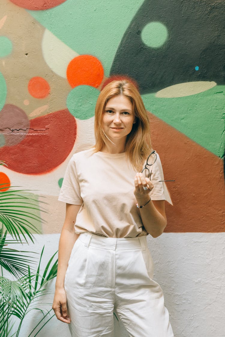 Woman In Beige Shirt Holding Eyeglasses