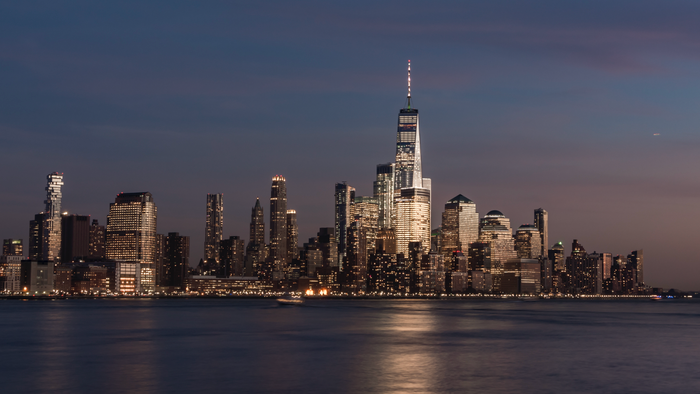 City skyline at sunset viewed across the water, evoking the imagery used by high end dating sites