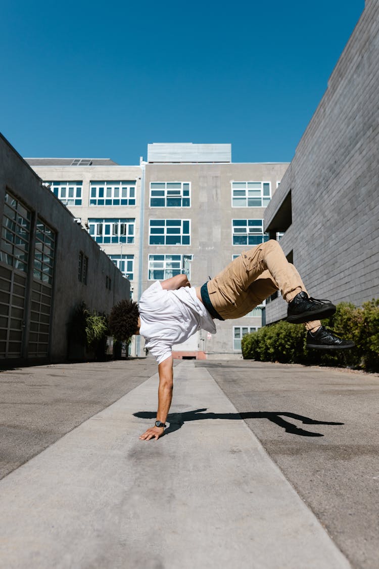 A Man In White Shirt Doing Hand Stand