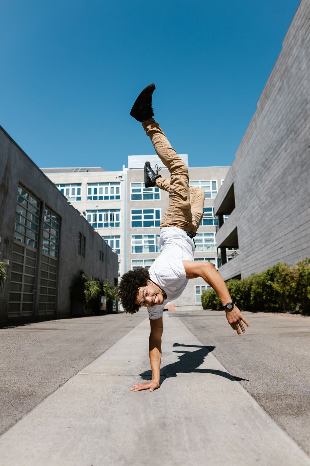 A street dancer performing a dynamic handstand in an urban setting