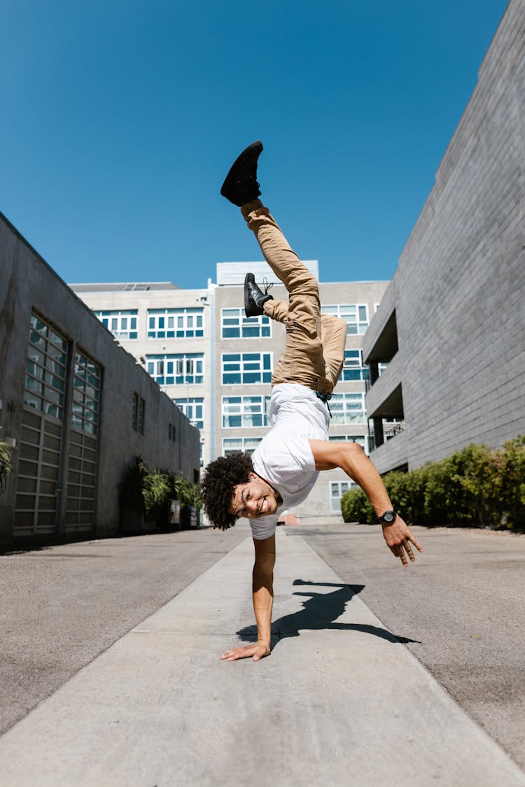 A Man In White Shirt Doing Hand Stand