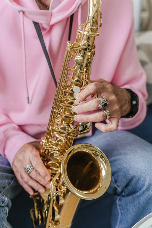 Person in Pink Long Sleeve Shirt Playing Saxophone