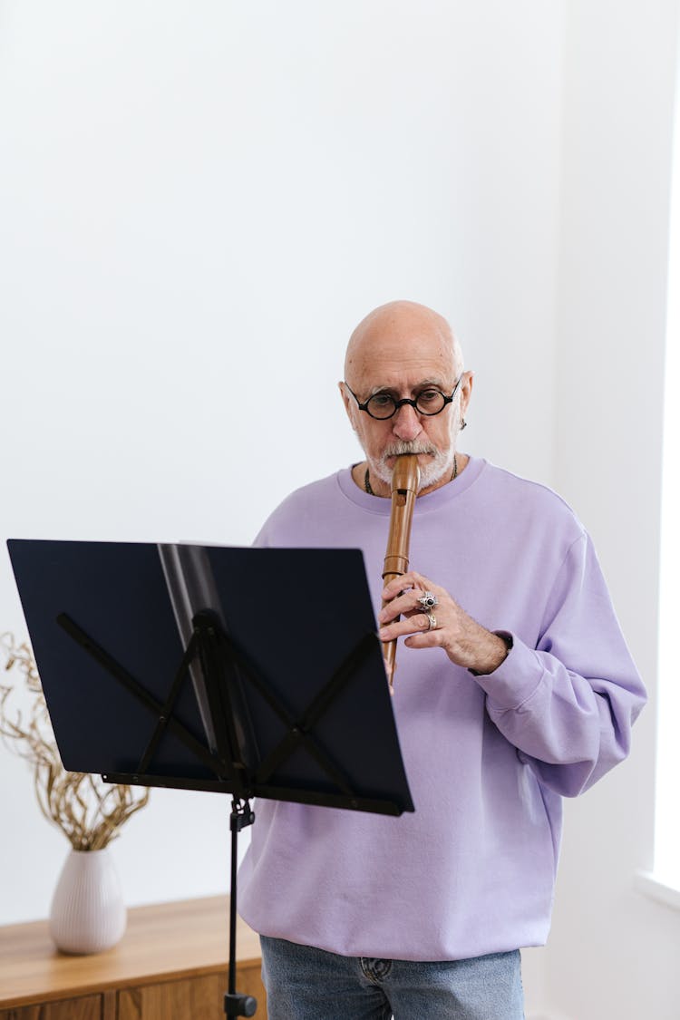 A Man In Purple Sweater Playing A Flute