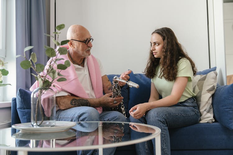 An Elderly Man Talking To A Woman While Sitting On The Couch