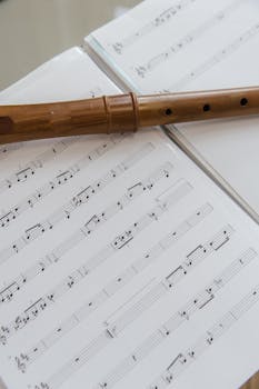 Close-up of a wooden flute resting on sheet music. Perfect for musical and artistic themes.