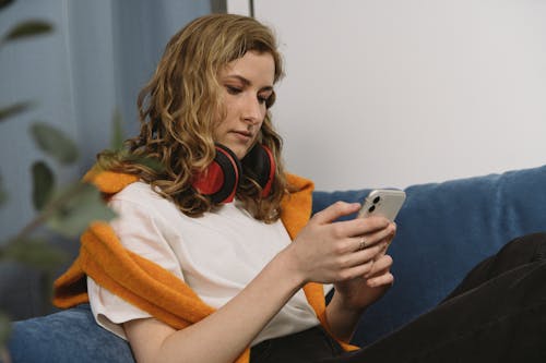 A Woman Sitting on the Sofa Using a Phone