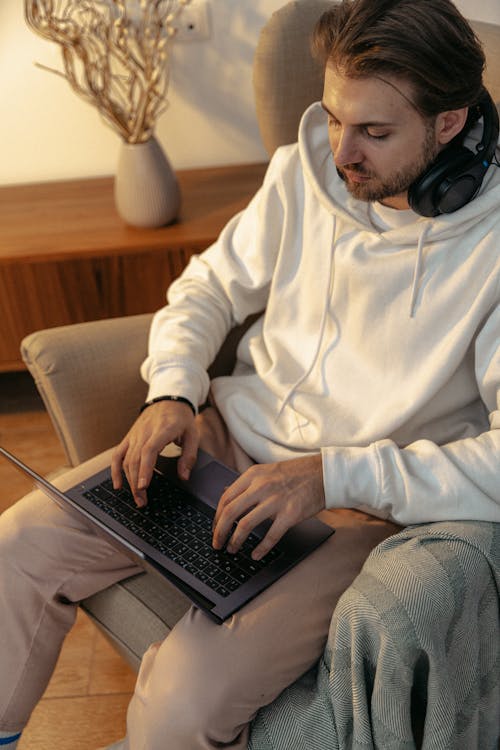Foto profissional grátis de casaco com capuz, computador portátil, dentro de casa