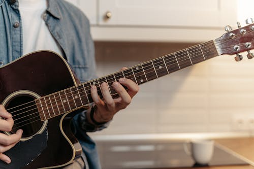 Бесплатное стоковое фото с акустическая гитара, бренчание, выборочный фокус