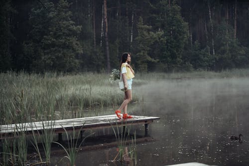 Free A Woman Standing Looking the Lake Stock Photo