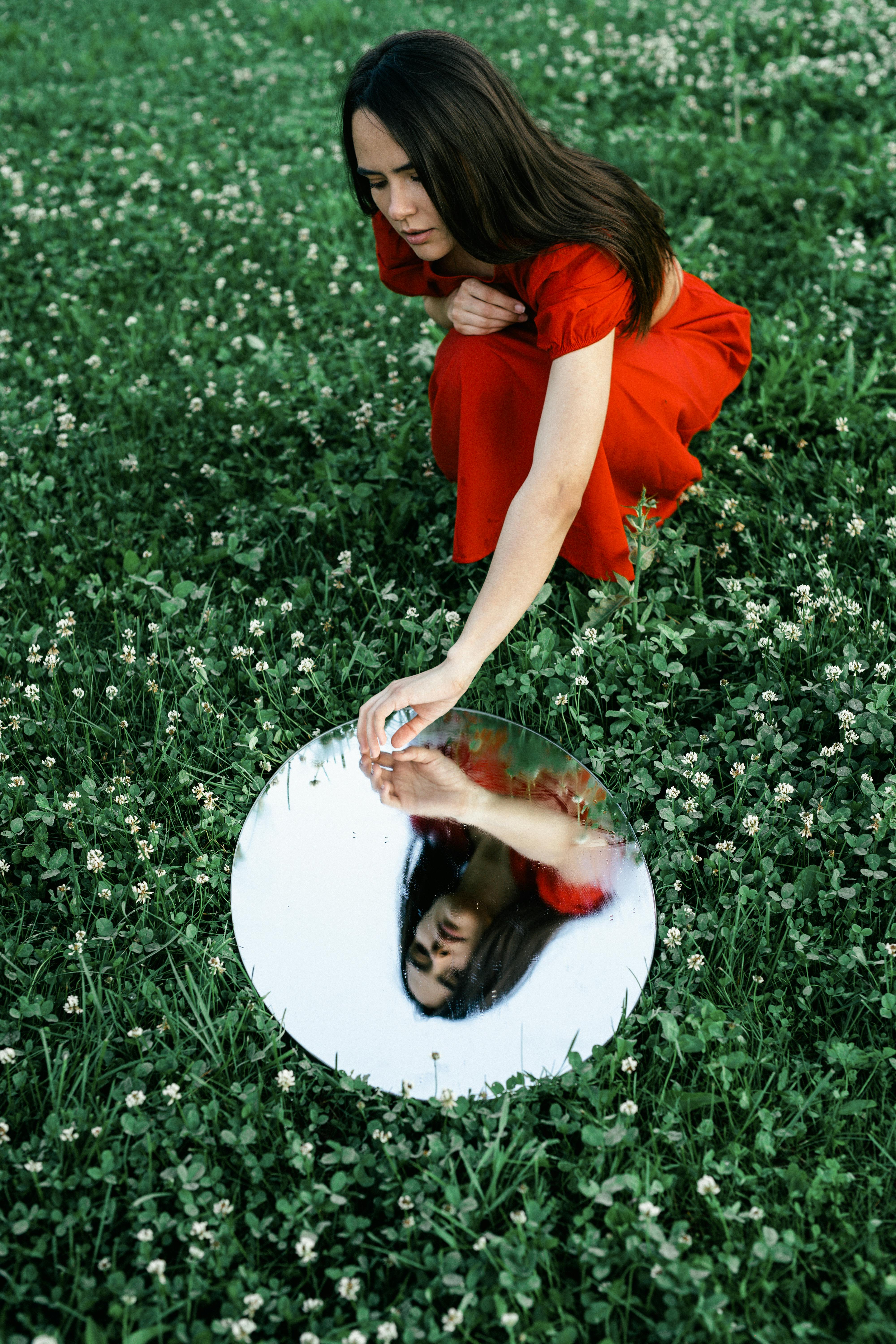 A Reflection of a Woman in a Red Dress in the Mirror