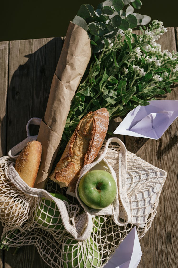 Apple, Bread And Flowers In Bag