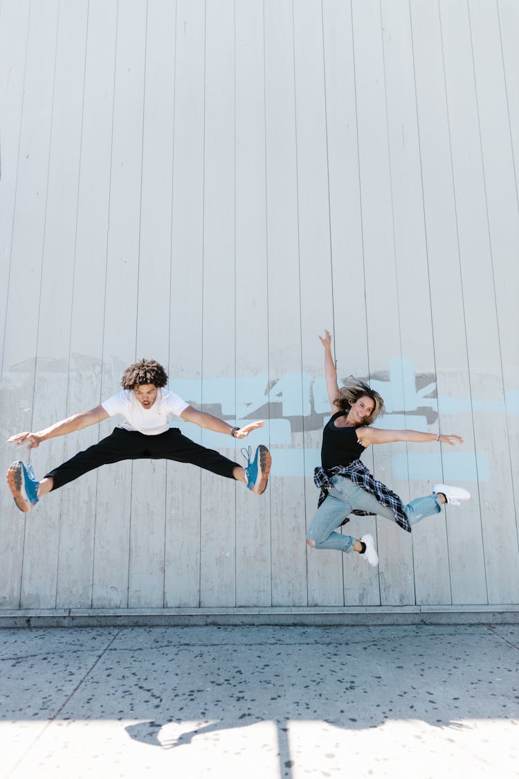 A Man And Woman Jumping On The Street