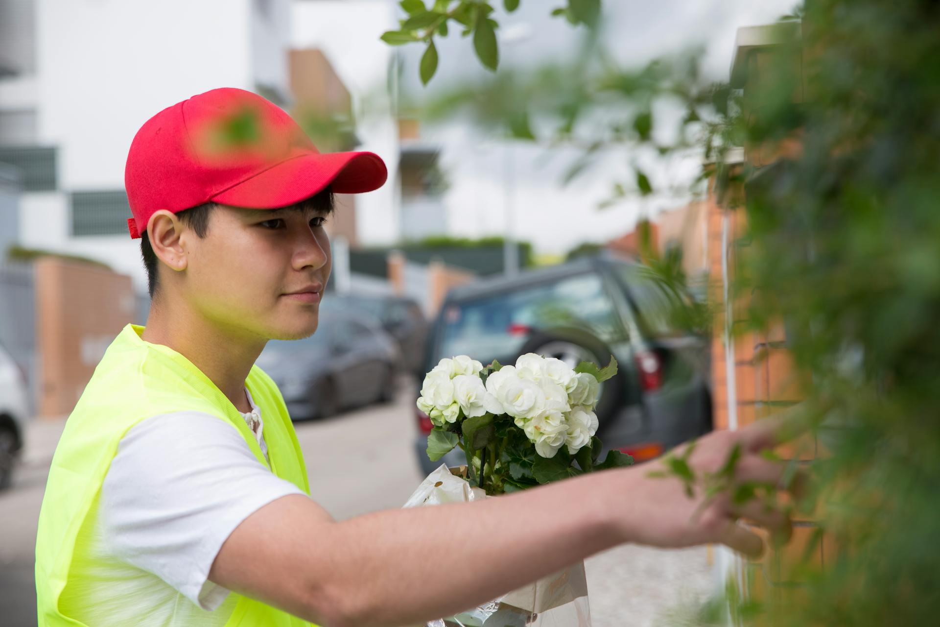 A courier delivering flowers to a residence in a Portuguese neighborhood.