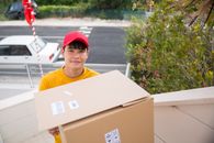 Man in Yellow Shirt Holding White Box