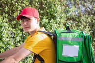 Man in Yellow and Black Polo Shirt Wearing Green and Black Backpack