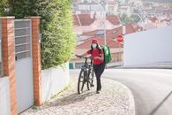 Man in Green Jacket Riding Bicycle on Road