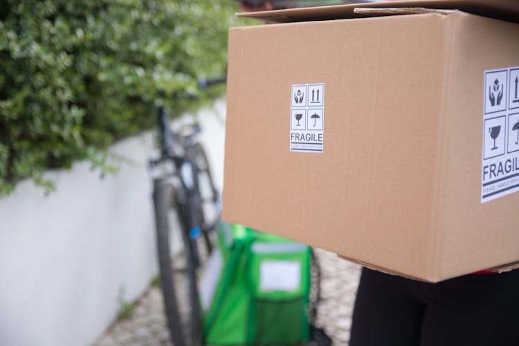 Brown Cardboard Box With Sign In Close-up Photography