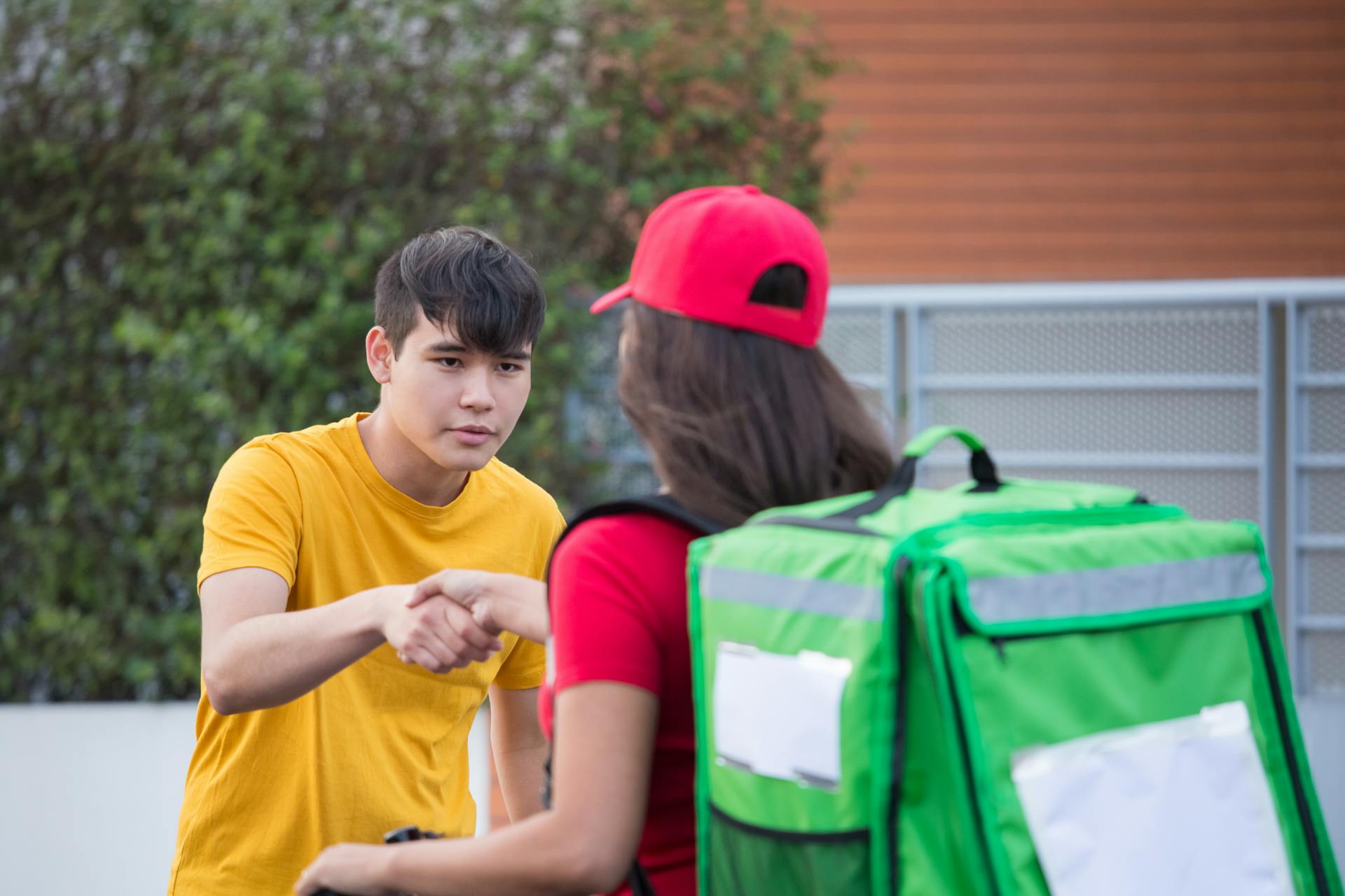 Woman Carrying a Green Backpack Delivering a Package