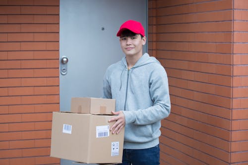 Free Man Wearing Gray Hoodie Carrying Boxes Stock Photo