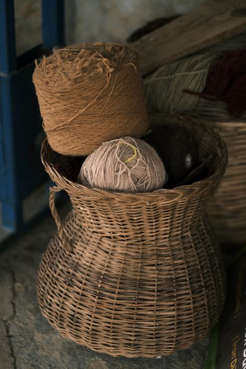 Free Woven wicker basket holding yarn balls, capturing a rustic and artistic atmosphere. Stock Photo