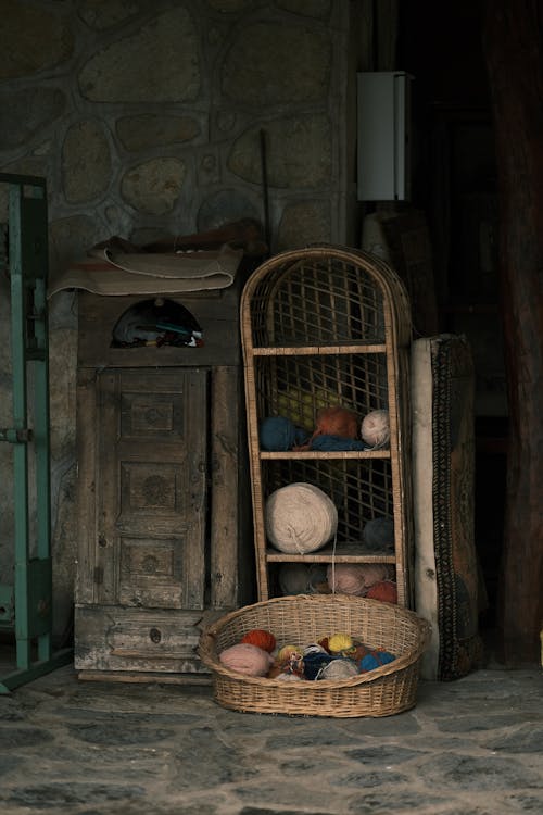 Sewing Threads on the Woven Basket and Shelf Beside the Wooden Cabinet