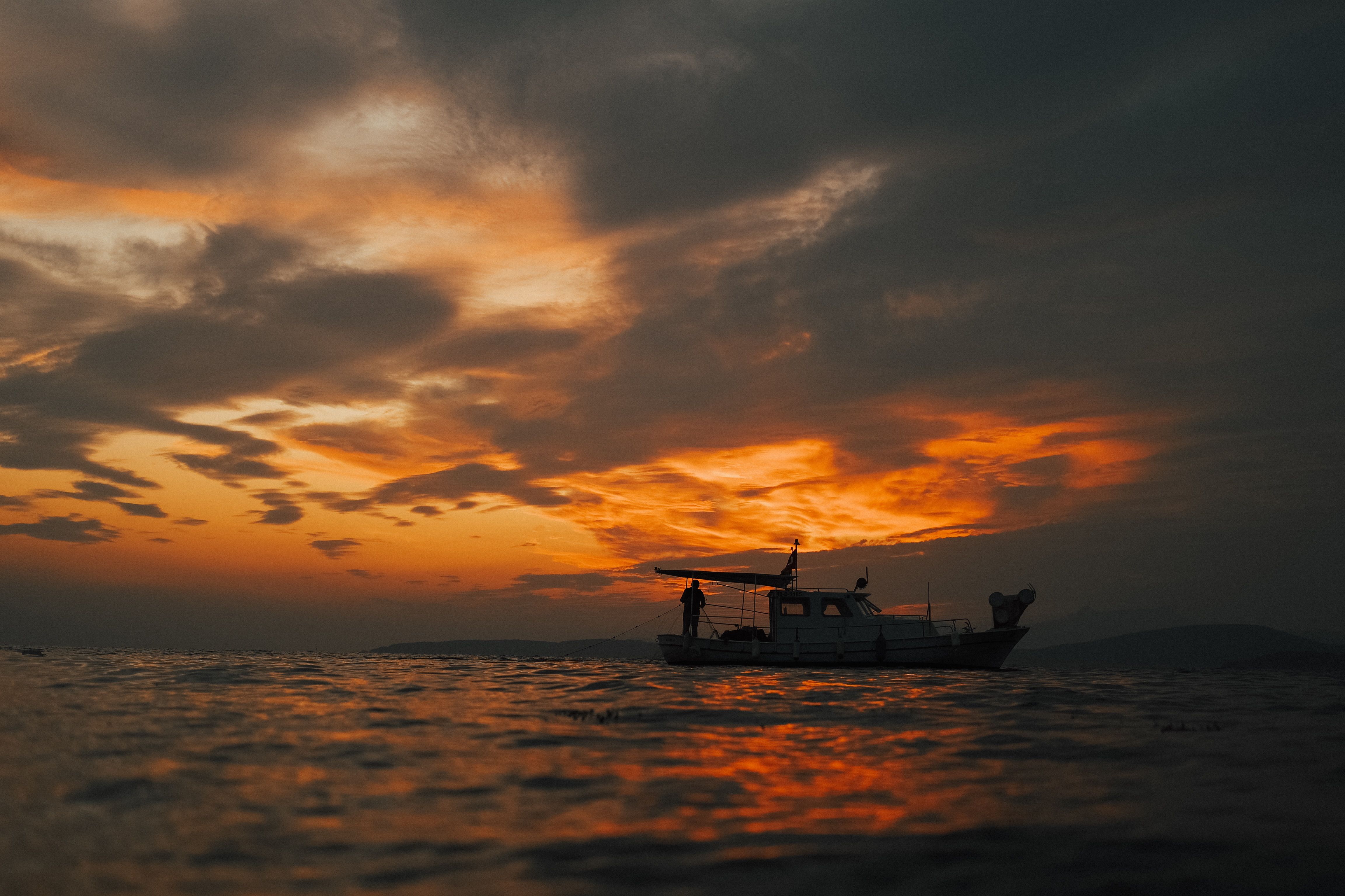 Silhouette of a Boat at Sea during Sunset · Free Stock Photo