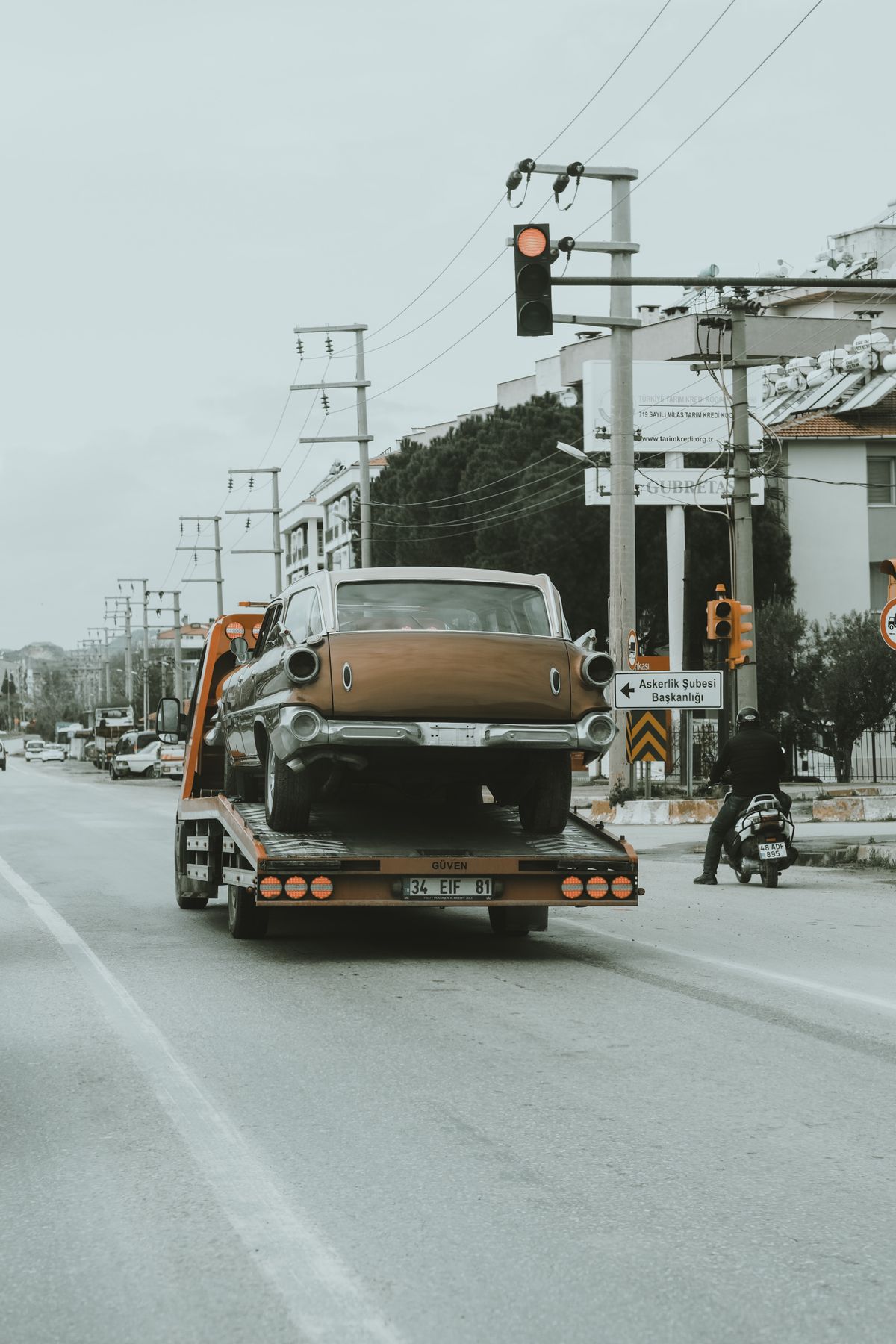 Vehículo clásico transportado en grúa por una avenida