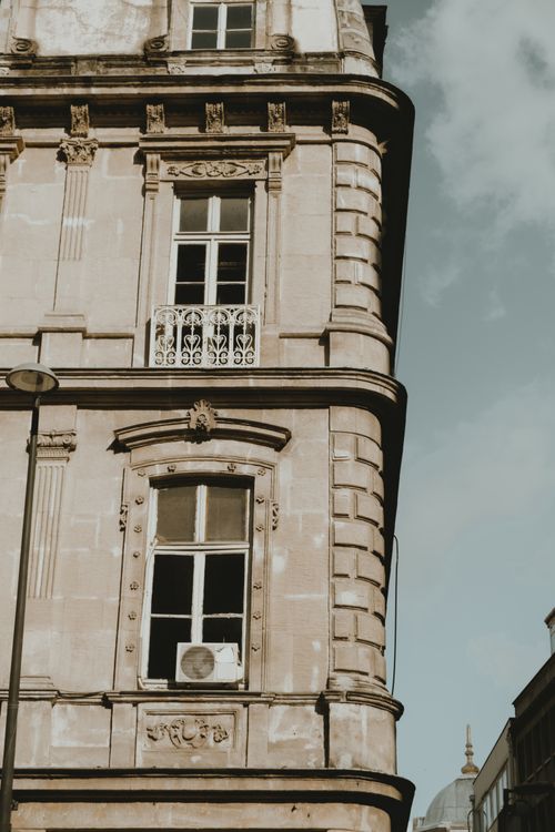 Free Close-up view of a historic European building with ornate windows and intricate details. Stock Photo