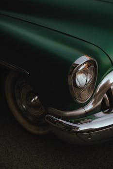 Close-up of a vintage green car's front with chrome detailing. Ideal for automotive enthusiasts.
