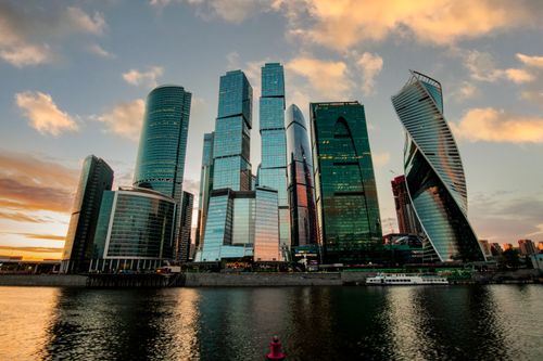Free Stunning skyline of Moscow City with modern skyscrapers reflecting in the river at sunset. Stock Photo