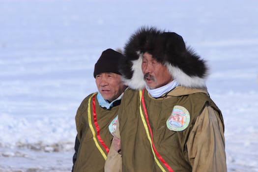 Elderly men in fur-lined winter jackets outdoors on a snowy day.