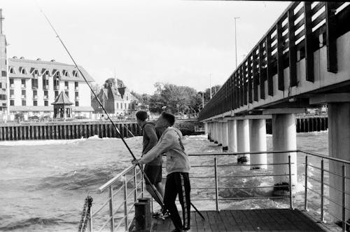 Grayscale Photo of Men Fishing
