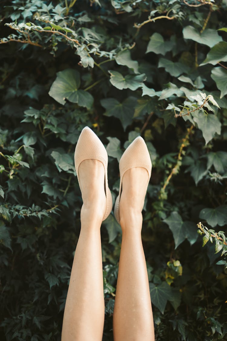 Person Wearing White Shoes Standing On Green Leaves