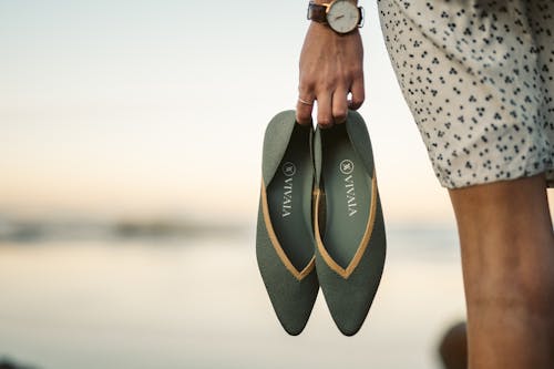 A Person Holding a Green Sandal Shoes